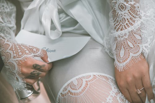 Anonymous gorgeous bride holding wedding vows letter before ceremony