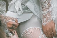 Anonymous gorgeous bride holding wedding vows letter before ceremony