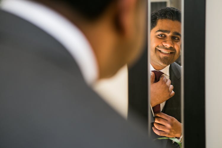 Smiling Happy Ethnic Man Adjusting Tie