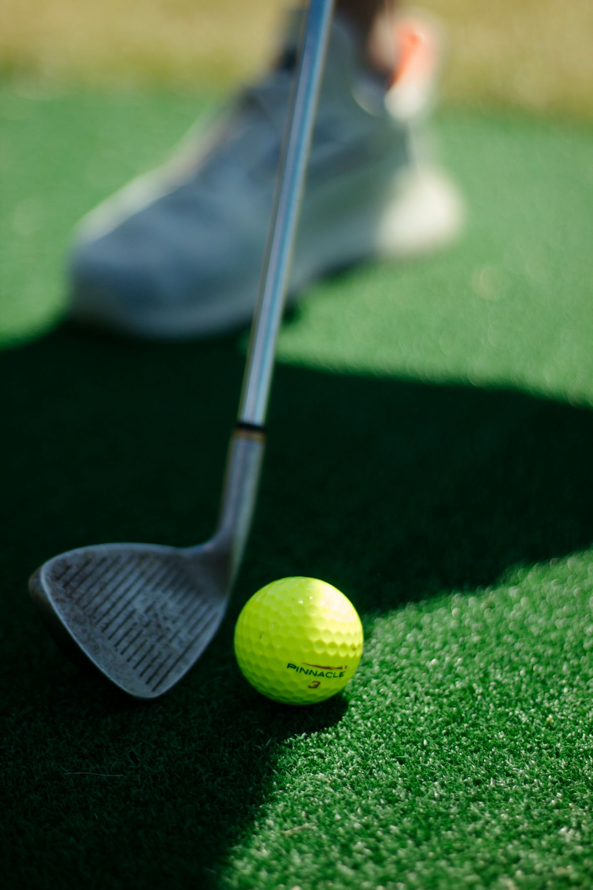 Wedge behind a golf ball on a practice green