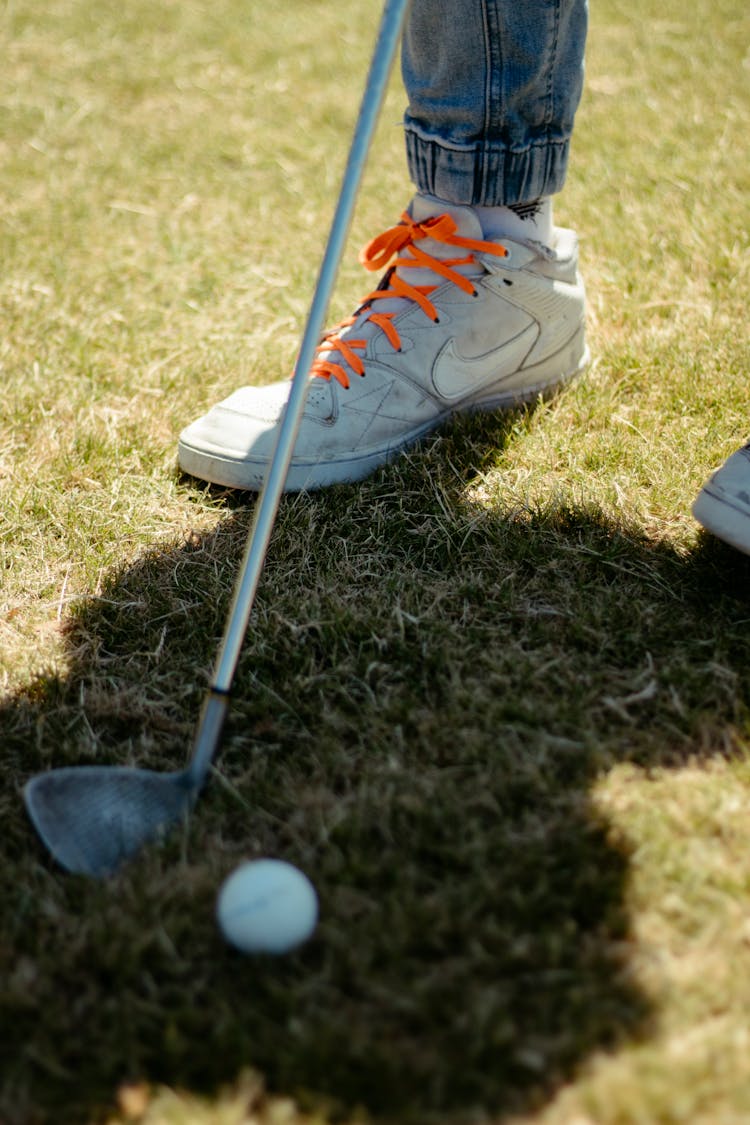 Golf Ball On Dry Grass Near Player