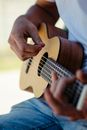 Crop anonymous male guitarist pinching chord on fretboard while spending free time in nature