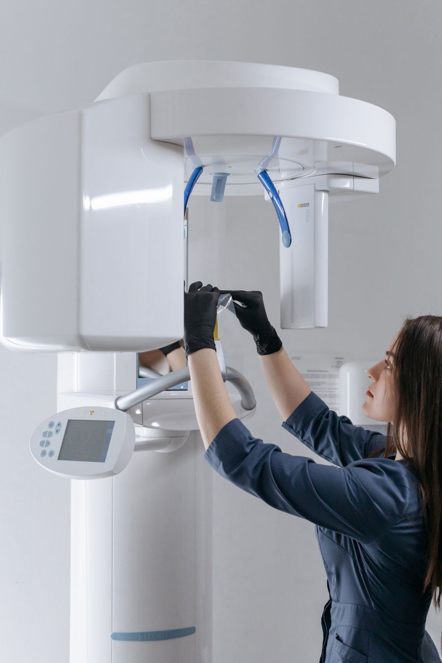 Técnica con guantes ajusta equipo médico de rayos X