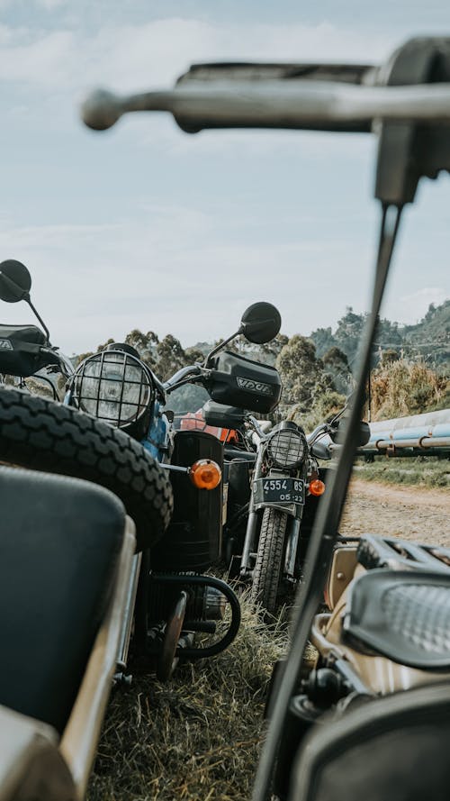 Vintage used broken motorcycles in different types placed in abandoned area for utilization