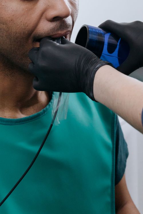 Free Close-up of a dental professional preparing a patient for an oral x-ray in a clinical setting. Stock Photo