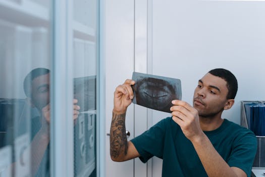 Young dentist examining a dental X-ray in a clinic setting. Professional healthcare practice.