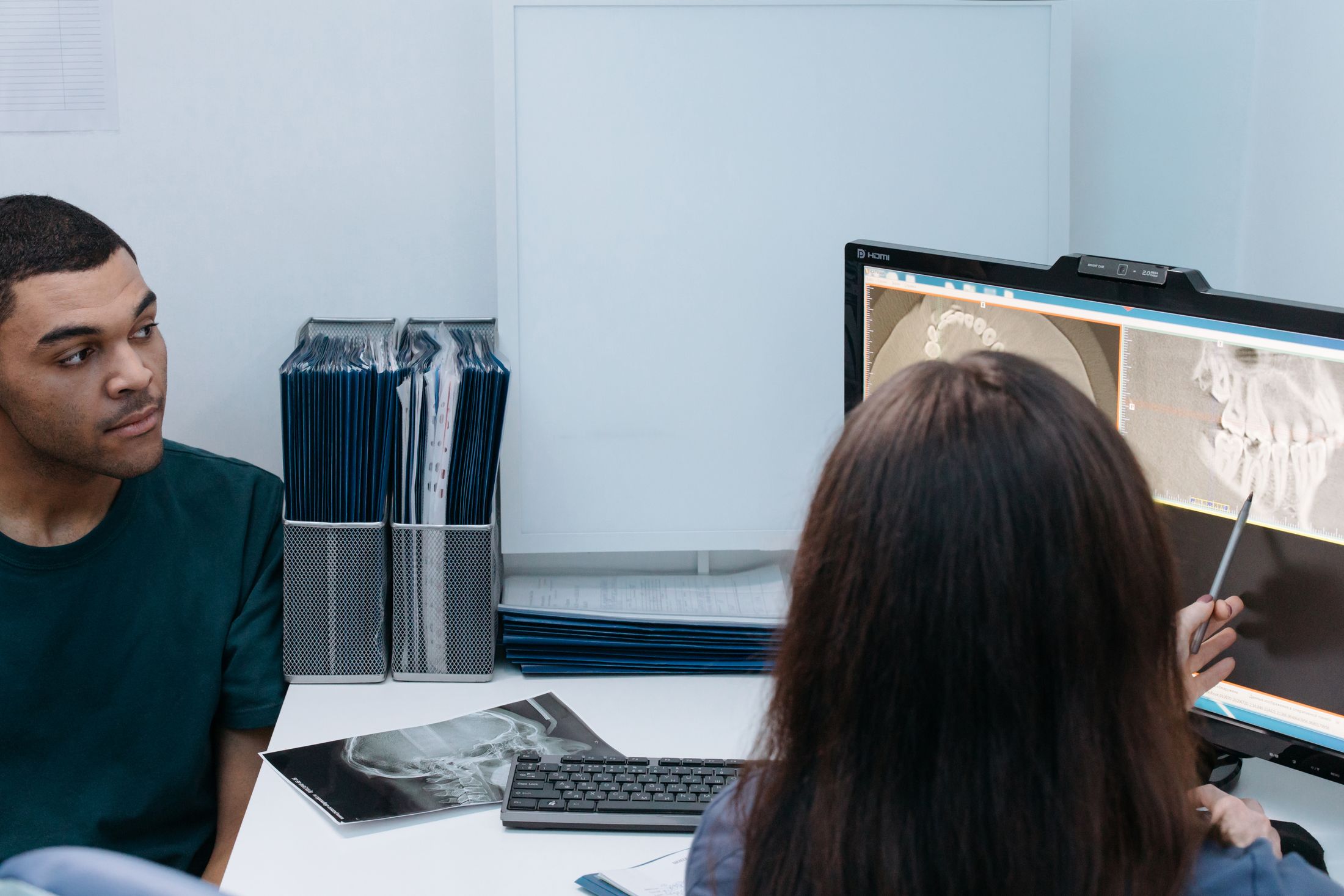 A dentist and patient discussing dental images together