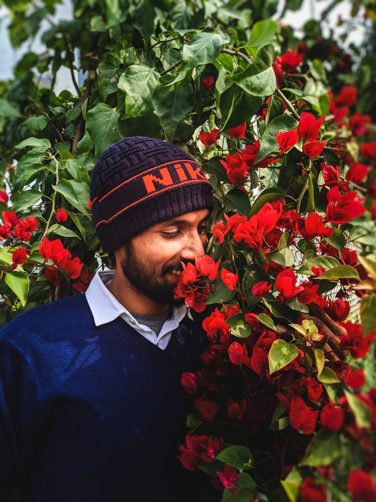 Man Smelling Red Flowers