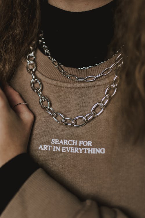 Faceless stylish woman in chain necklace and sweatshirt