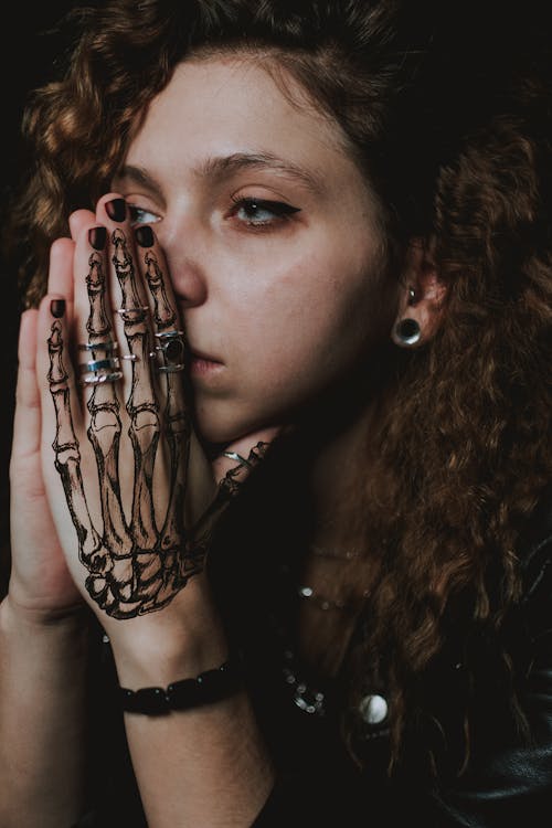 Free Thoughtful young tattooed lady praying and looking away Stock Photo
