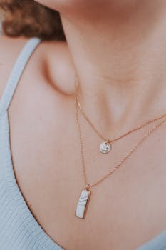 Close-up of a woman's neck showcasing elegant gold necklaces and minimalist fashion.