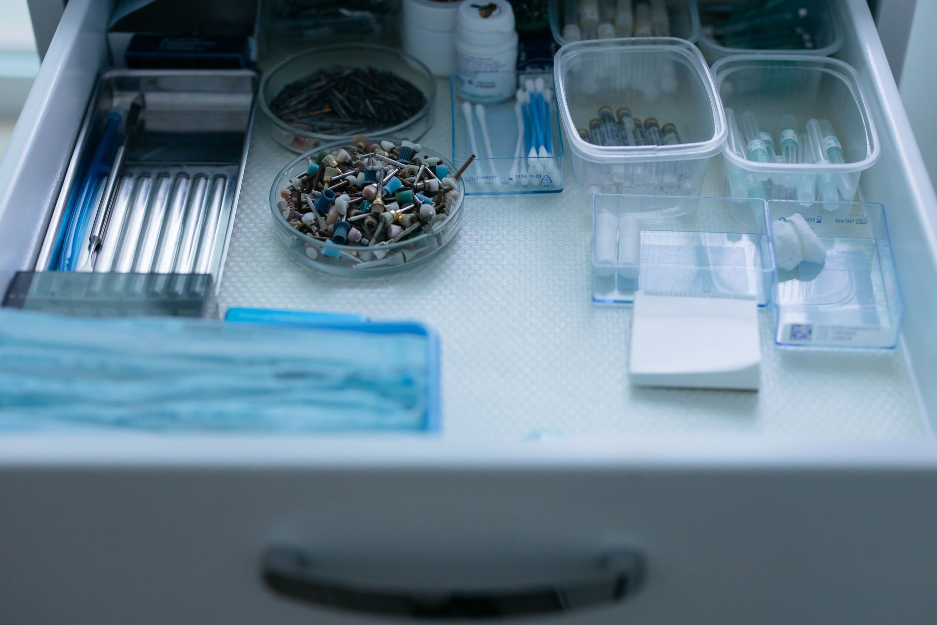 A detailed view of organized dental tools and equipment in a drawer, emphasizing cleanliness and dental care.