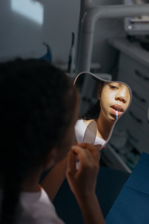 Free A Kid Checking Her Teeth in the Mirror Stock Photo