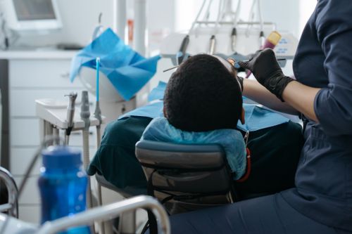 Free A dentist performing a checkup on a patient at a dental clinic, focusing on oral health. Stock Photo