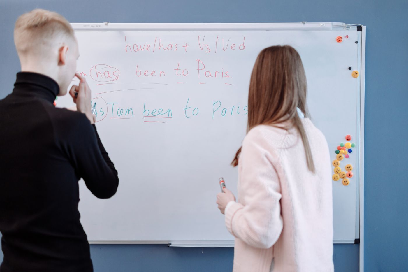 Tutor explaining a lesson to students using a whiteboard