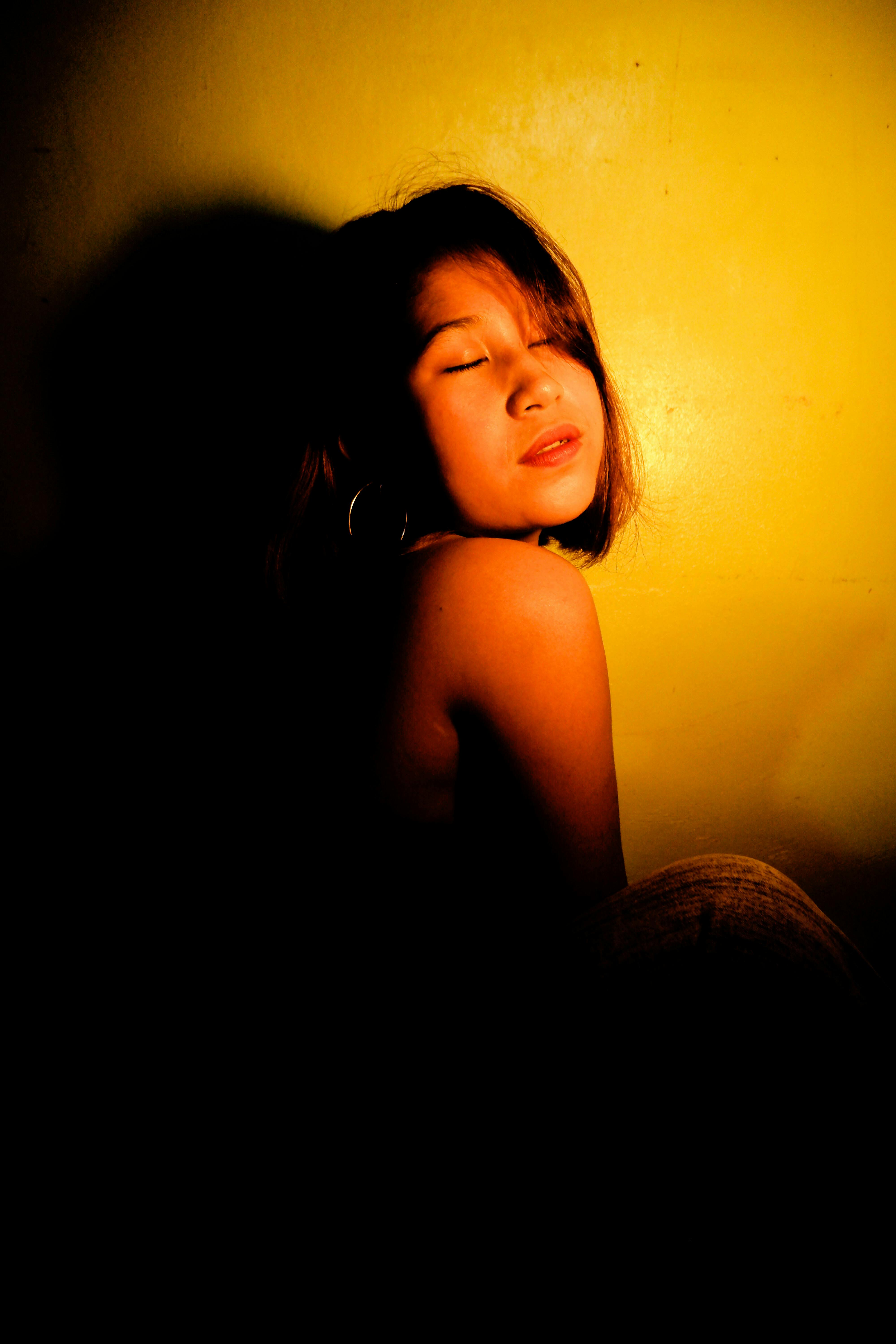 Young Woman Under Light In Dark Room Free Stock Photo Young Woman Under Light In Dark Room Free Stock Photo