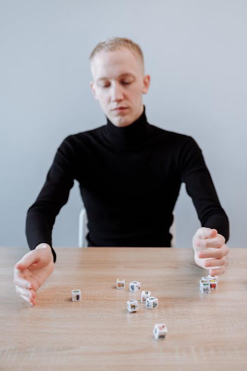 Man in Black Sweater Playing with Dices