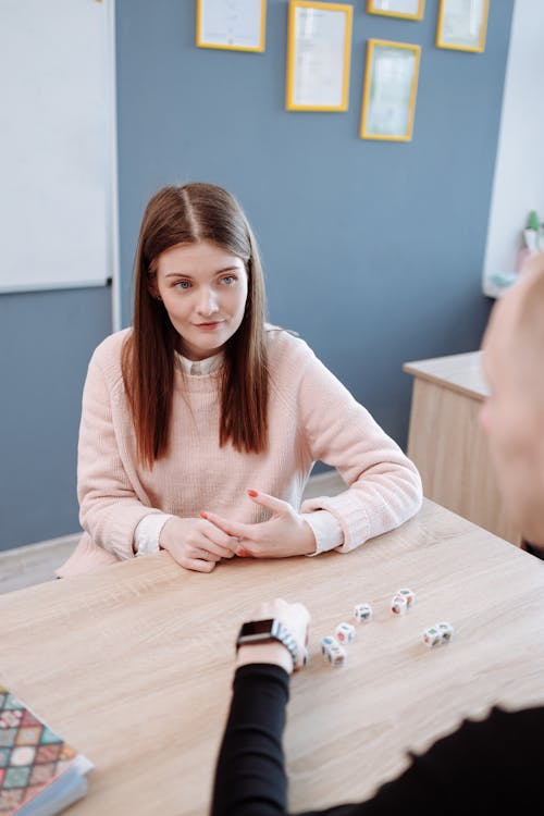 Woman in Pink Sweater Playing with Dices