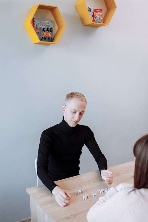 Man in Black Sweater Playing with Dices