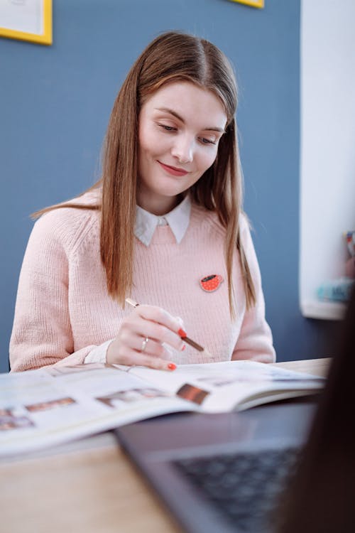 Woman in Pink Sweater Reading a Book