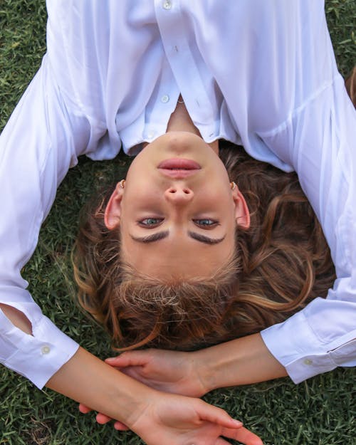 Free Woman Lying on the Grass and Looking at Camera Stock Photo
