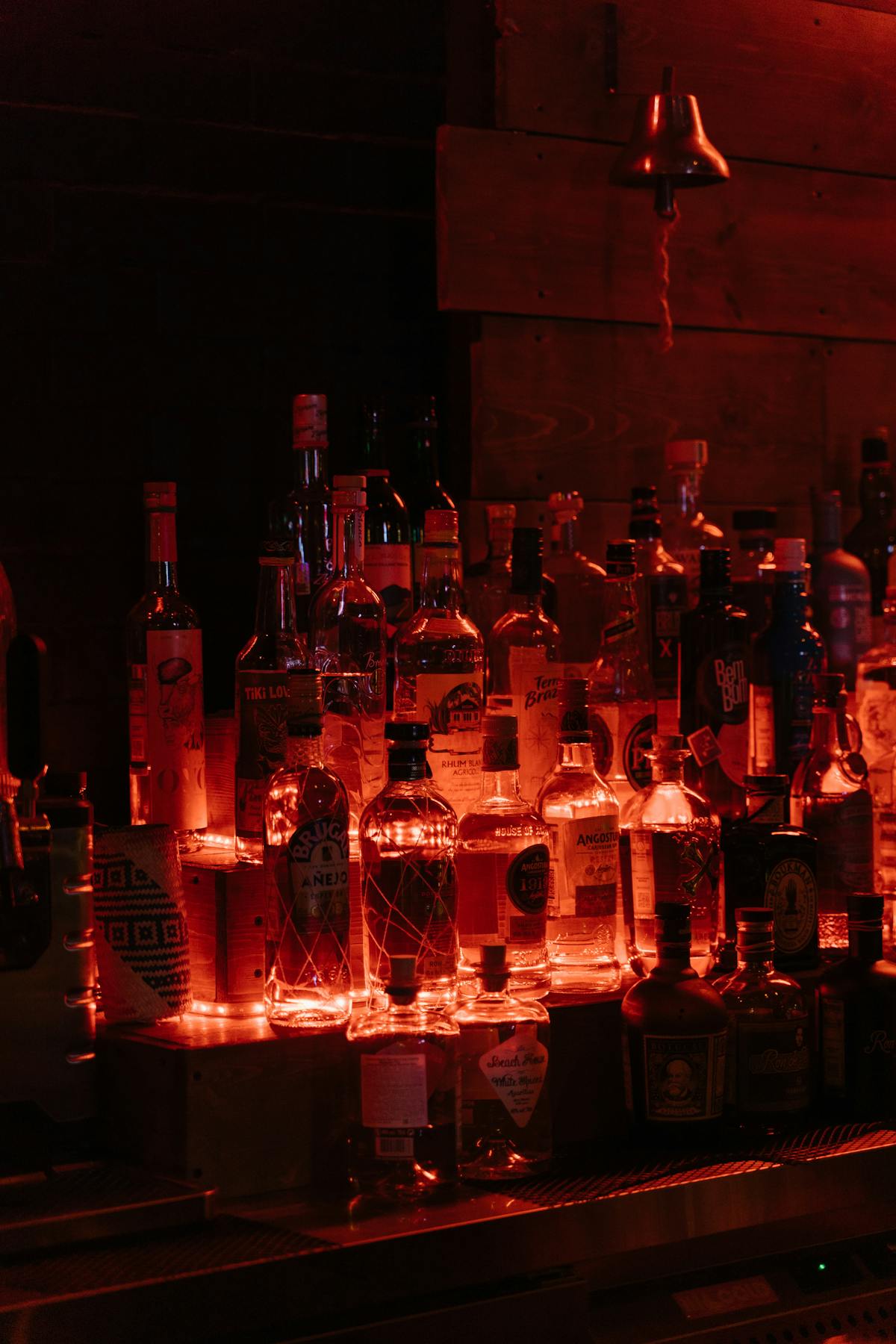 Bottiglie del bar illuminate disposte ordinatamente sul bancone