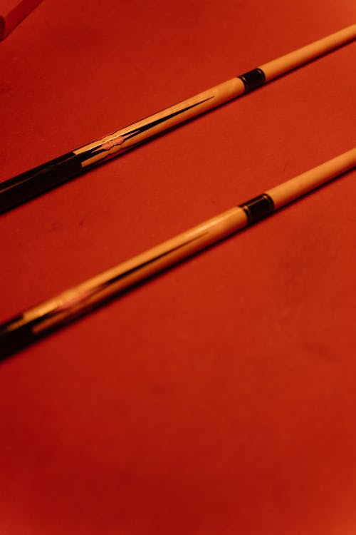 Close-Up Photo of Cue Sticks on Billard Table