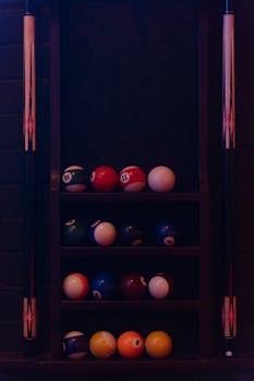 A close-up view of a rack of billiard balls alongside cue sticks, perfect for pool enthusiasts.