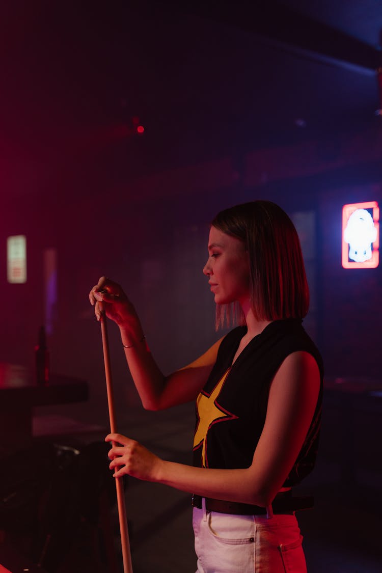 A Woman Applying Chalk On Cue Stick