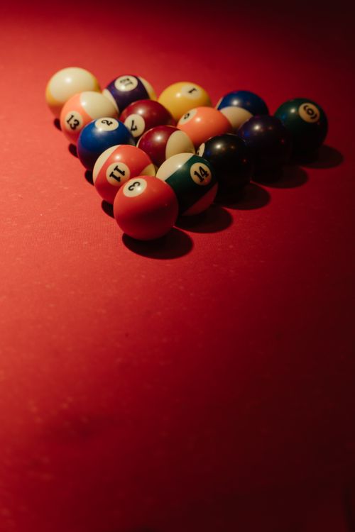 Free A close-up view of colorful billiard balls arranged on a red baize table, perfect for sports-themed designs. Stock Photo