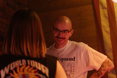 Free Two adults having a friendly conversation indoors. Warm lighting and casual atmosphere. Stock Photo