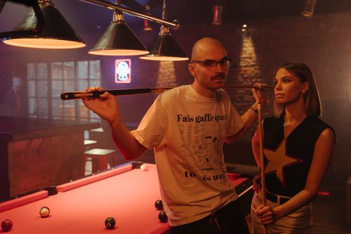 Free A couple enjoying a game of pool together in a dimly lit bar. Stock Photo