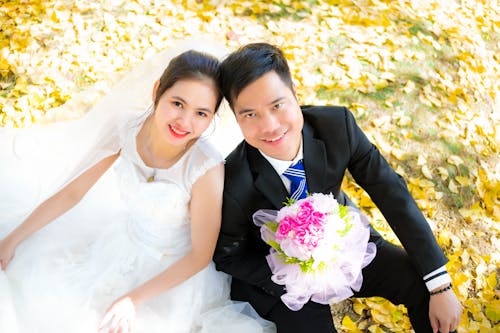 Portrait of a Smiling Bride and Groom in a Park at Fall 