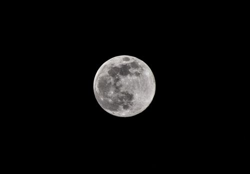 Free Stunning full moon captured in detail against a dark night sky, showcasing lunar features and craters. Stock Photo