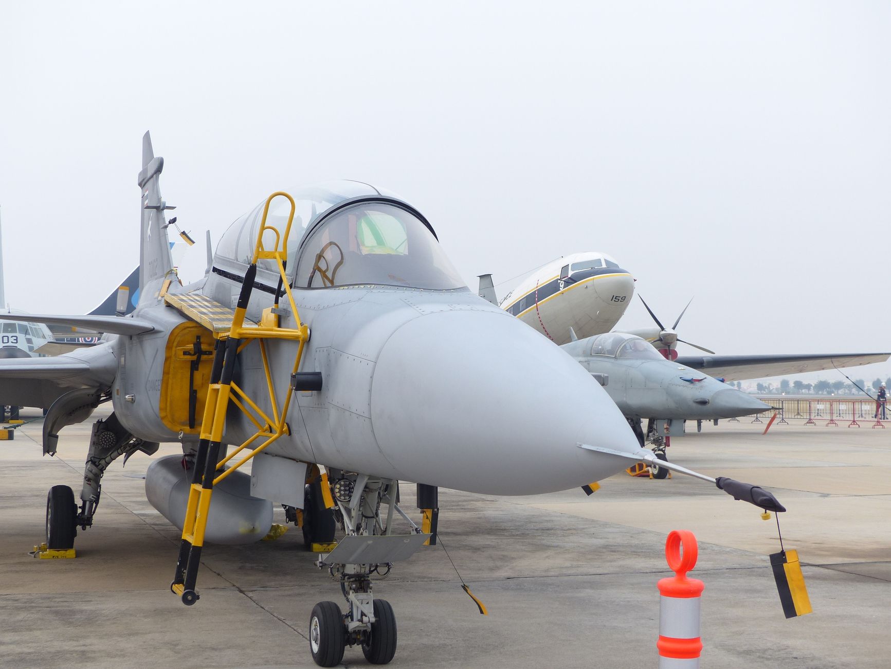 Close-up view of a fighter jet parked at an airport during the day.