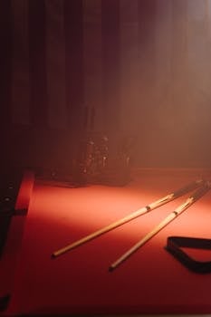 A moody still life of cue sticks on a billiard table with soft atmospheric lighting.