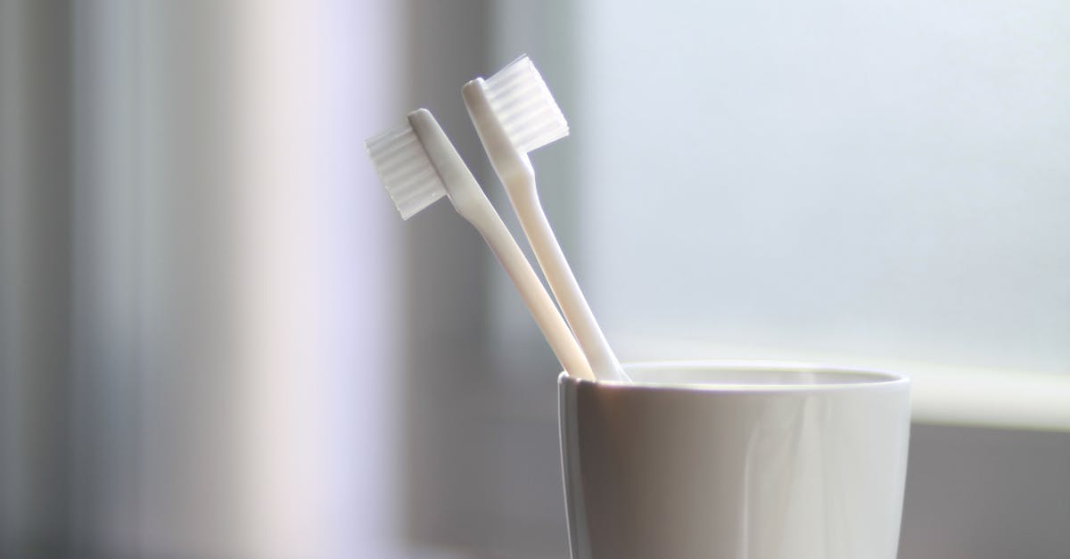 Two White Toothbrush Inside the White Ceramic Cup