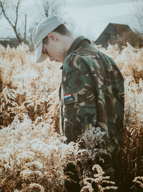 Man Wearing a Military Uniform Standing on a Grass Field