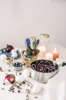 Aesthetic kitchen setup featuring red cabbage, eggs, candles, and flowers for spring.