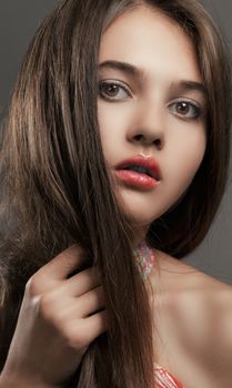 A beautiful, elegant close-up portrait of a young woman with long hair and brown eyes.