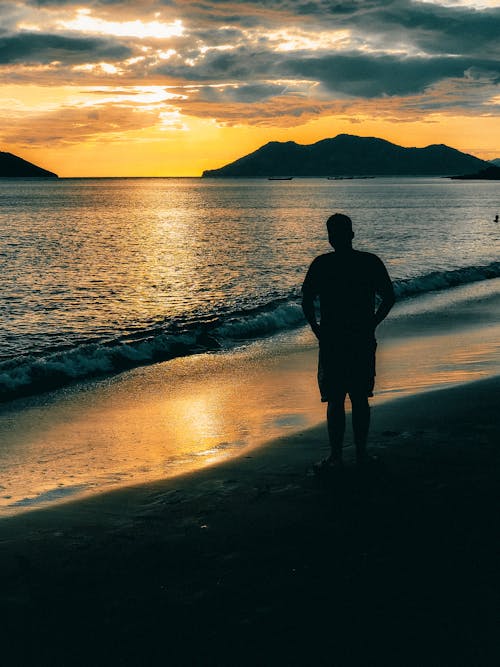 Silhouette of Man Standing on Shore