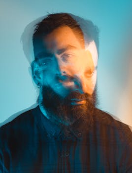 Artistic double exposure portrait of a bearded man with cool lighting effect.