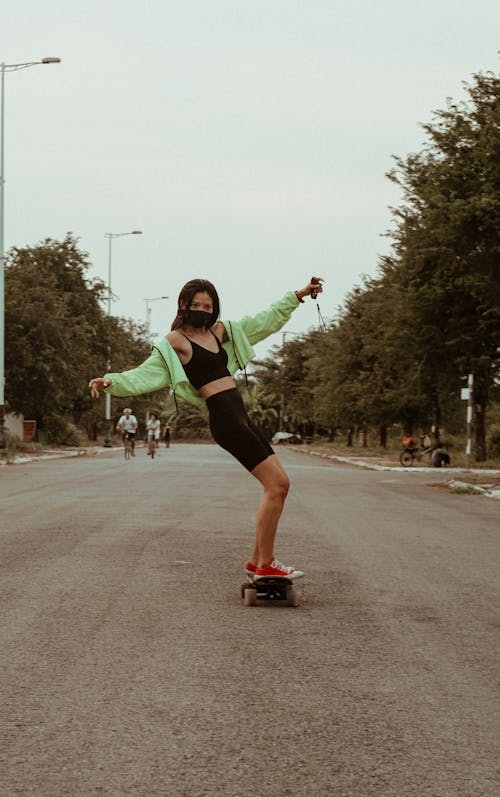 A Woman Wearing Activewear and Skateboarding