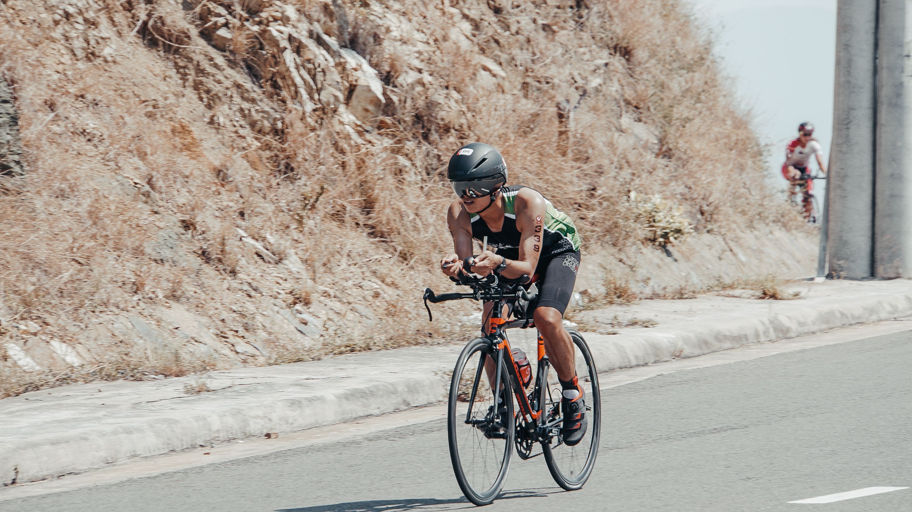 Man cycling on a sunny day in Nha Trang, Vietnam, showcasing fitness and dedication.