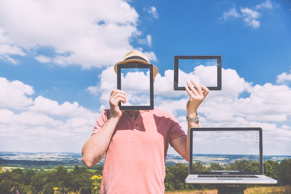 Standing Man Holding Ipads Near Macbook Pro