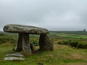 Gray Rock Formation on Green Grass Field Under White Sky