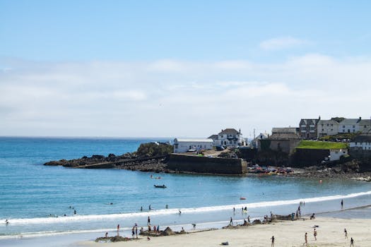 Beautiful sunny day at Coverack Beach, showcasing the coast and activities.