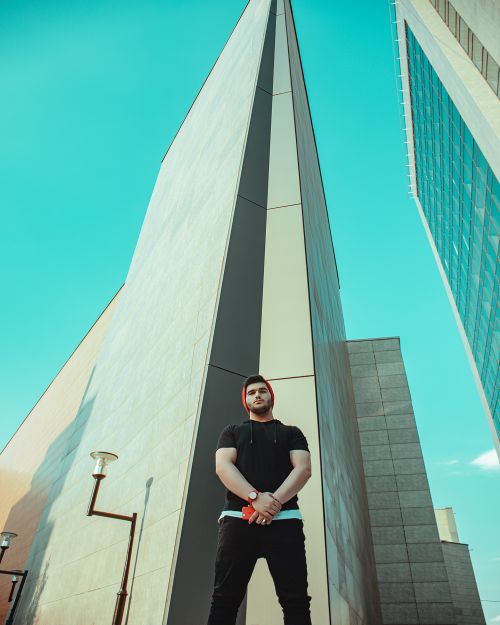 Free Low angle shot of a man standing by modern architecture in Mashhad, Iran. Stock Photo