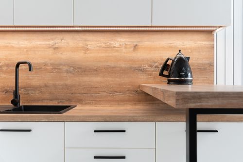 Free Fragment of interior of contemporary kitchen with white cabinets and wooden details in minimalist style apartment Stock Photo