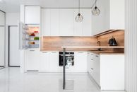 Interior of contemporary light kitchen with white furniture and modern appliances
